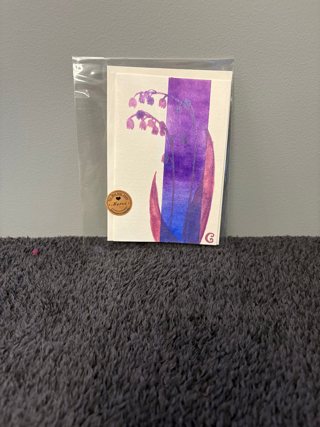 Card with floral design in a clear plastic sleeve 