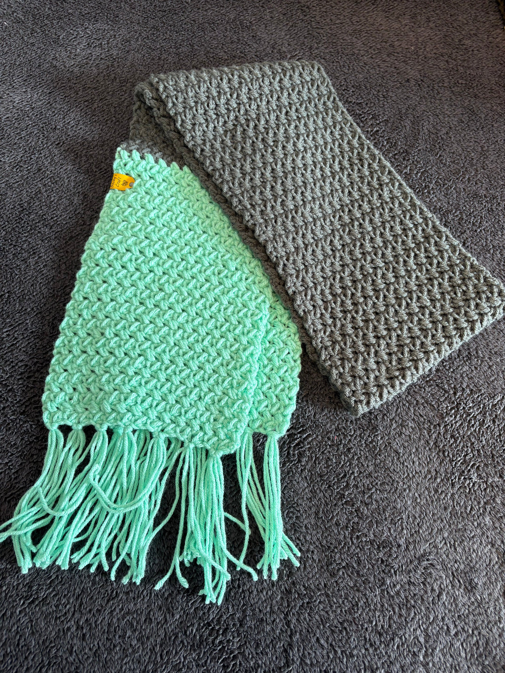 Gray and green knitted scarf on a dark textured surface