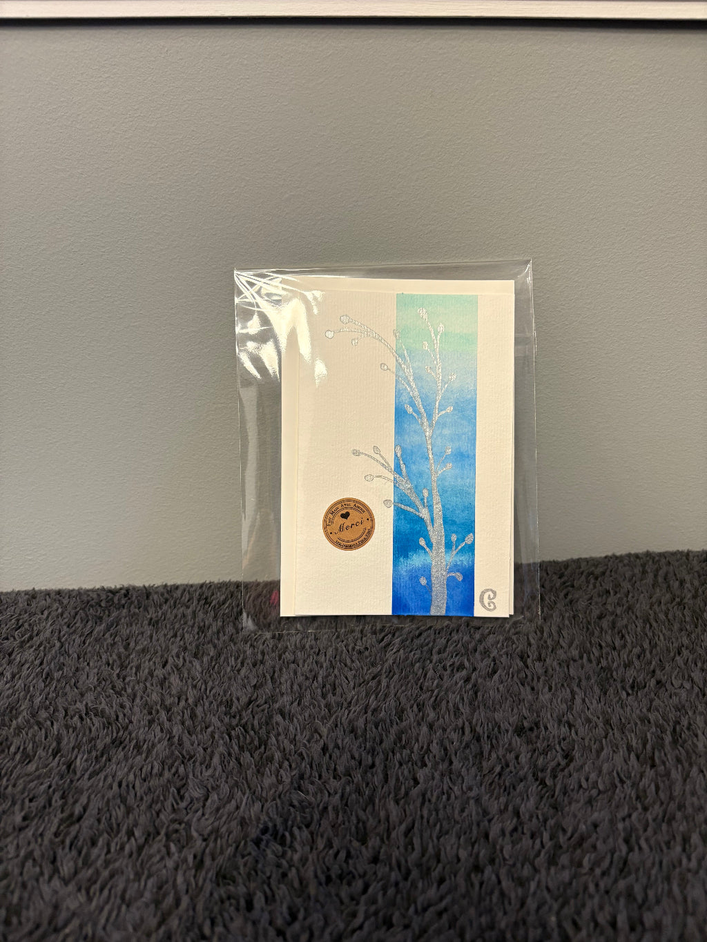 Card with floral design in a clear plastic sleeve 