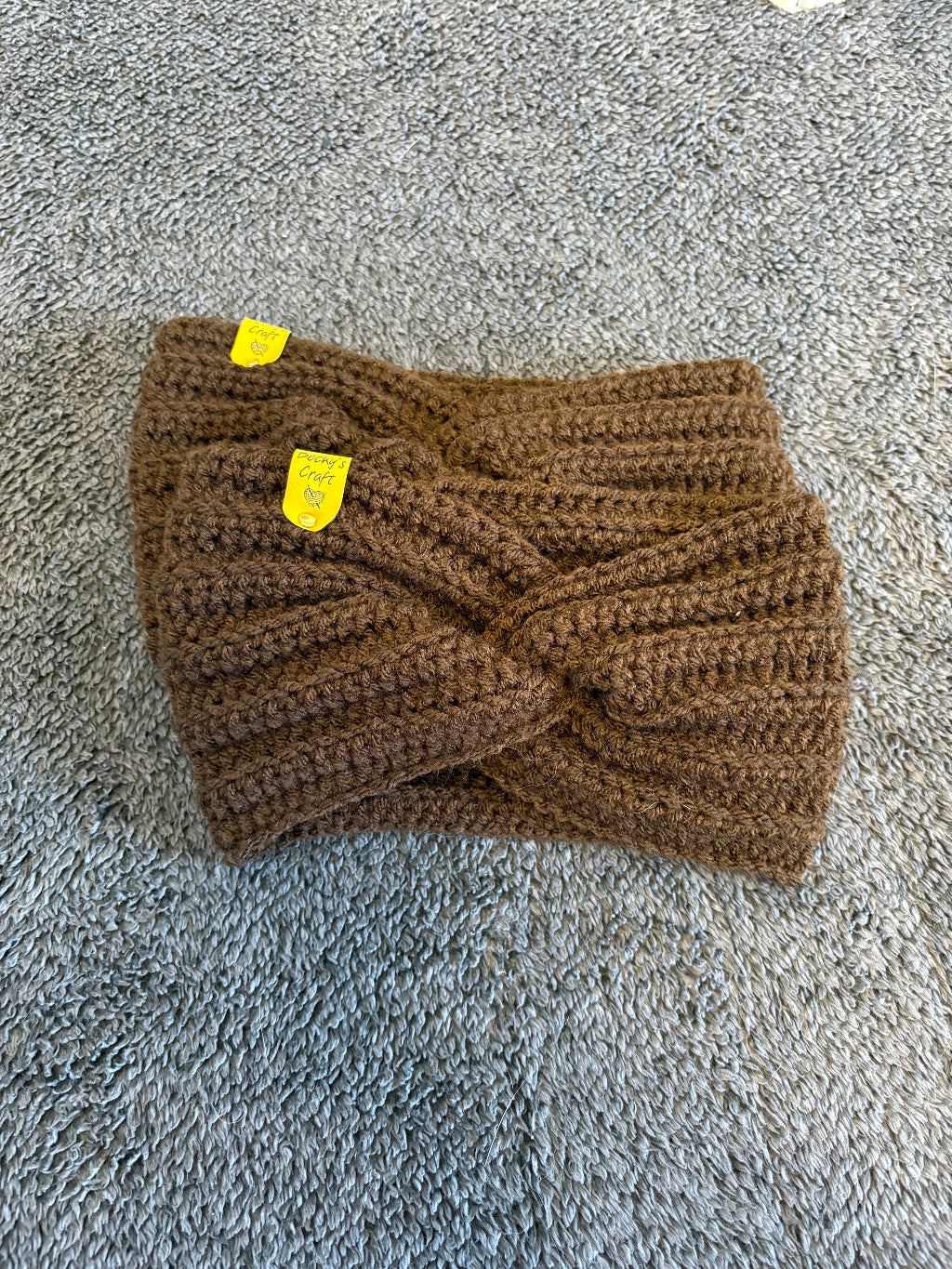 Brown knitted headband with a yellow tag