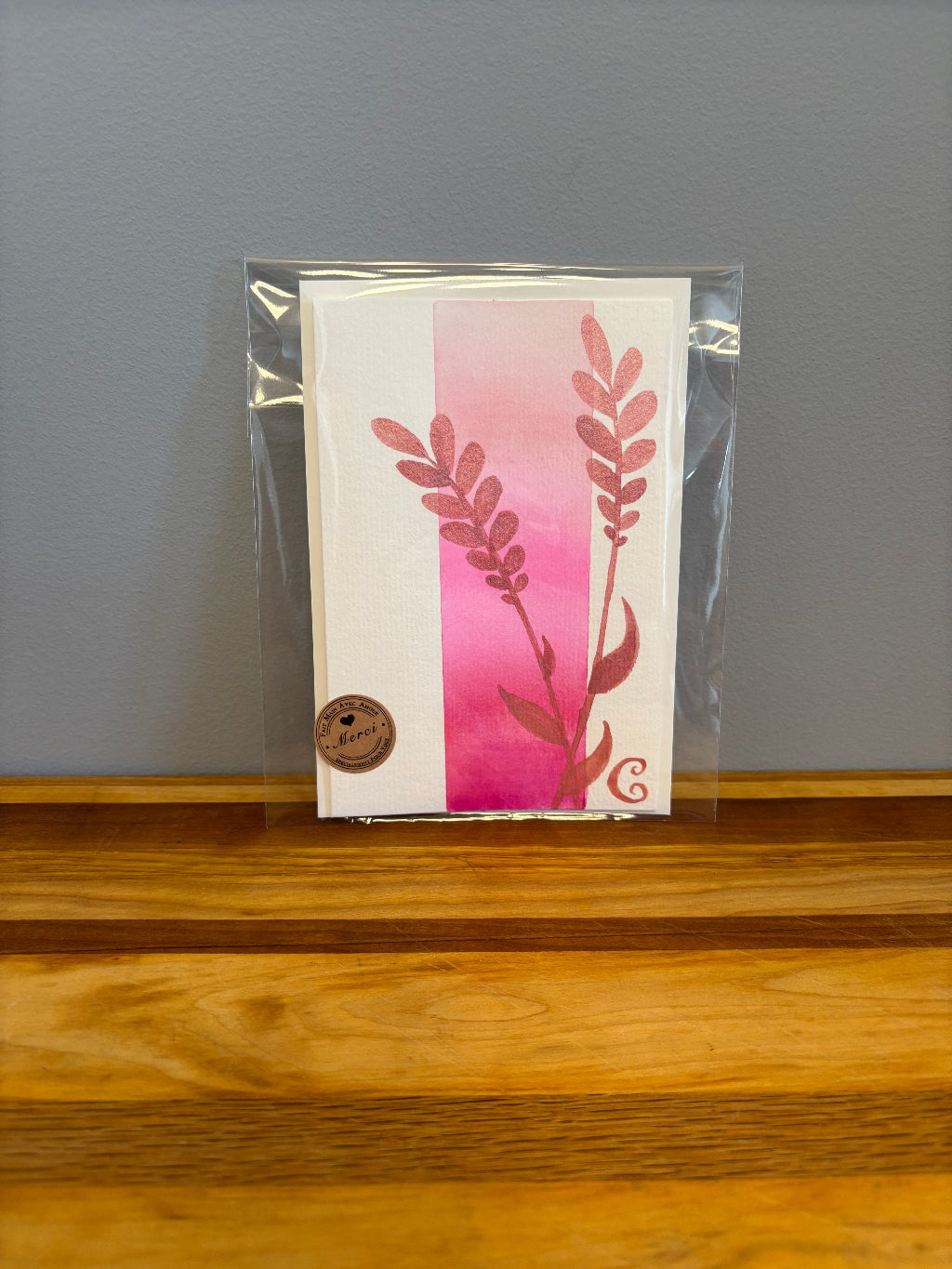 Packaged card with floral design on a gray surface