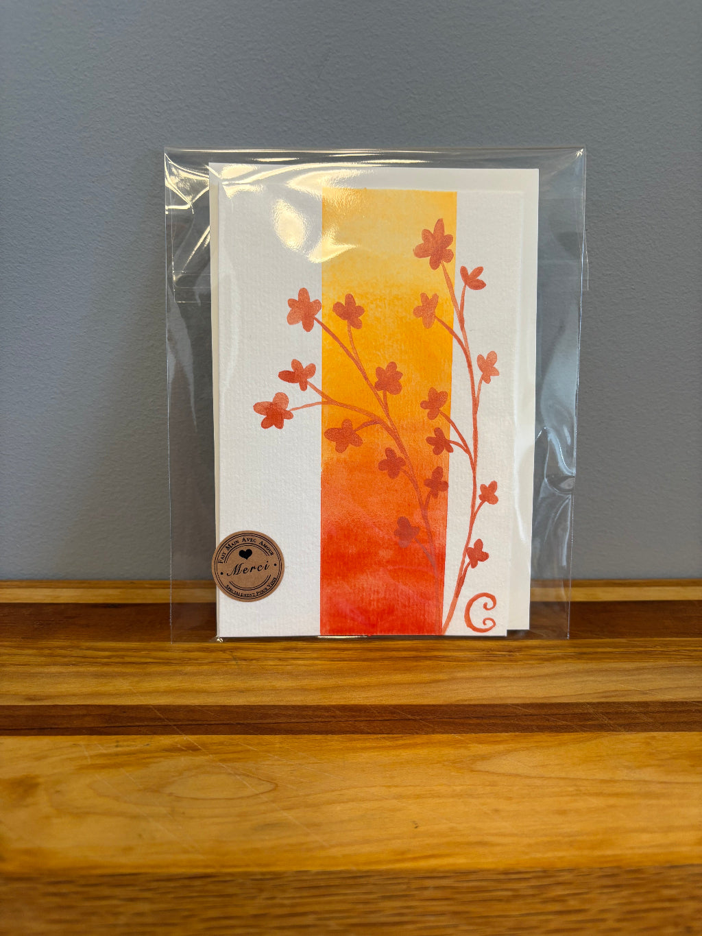 Packaged card with floral design on a gray surface