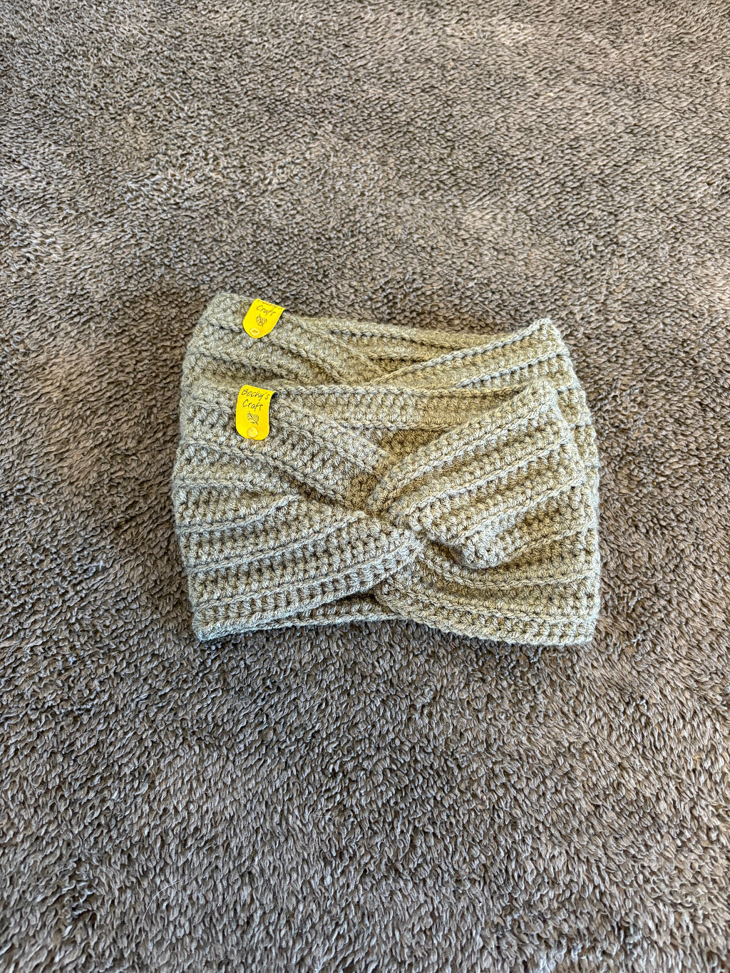 Knitted item with yellow tags on a textured gray surface