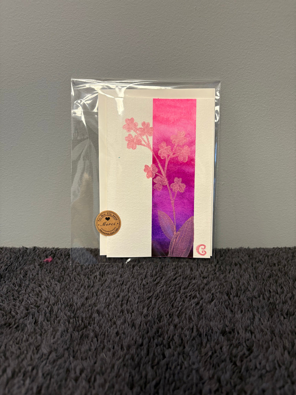 Card with floral design in a clear plastic sleeve 