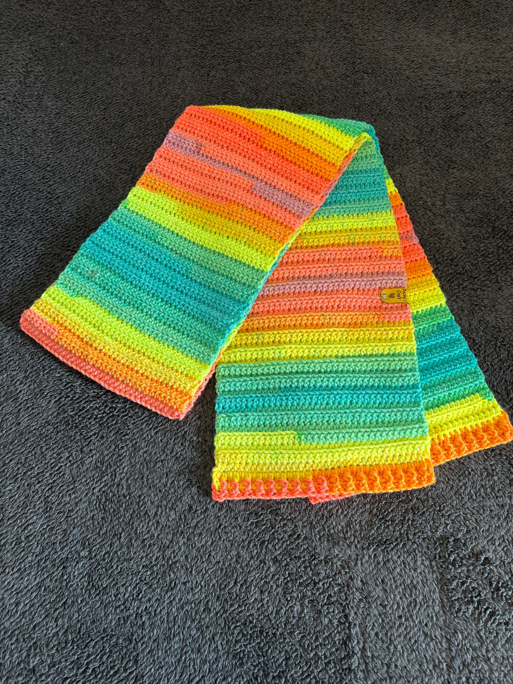 Colorful striped scarf on a dark textured surface