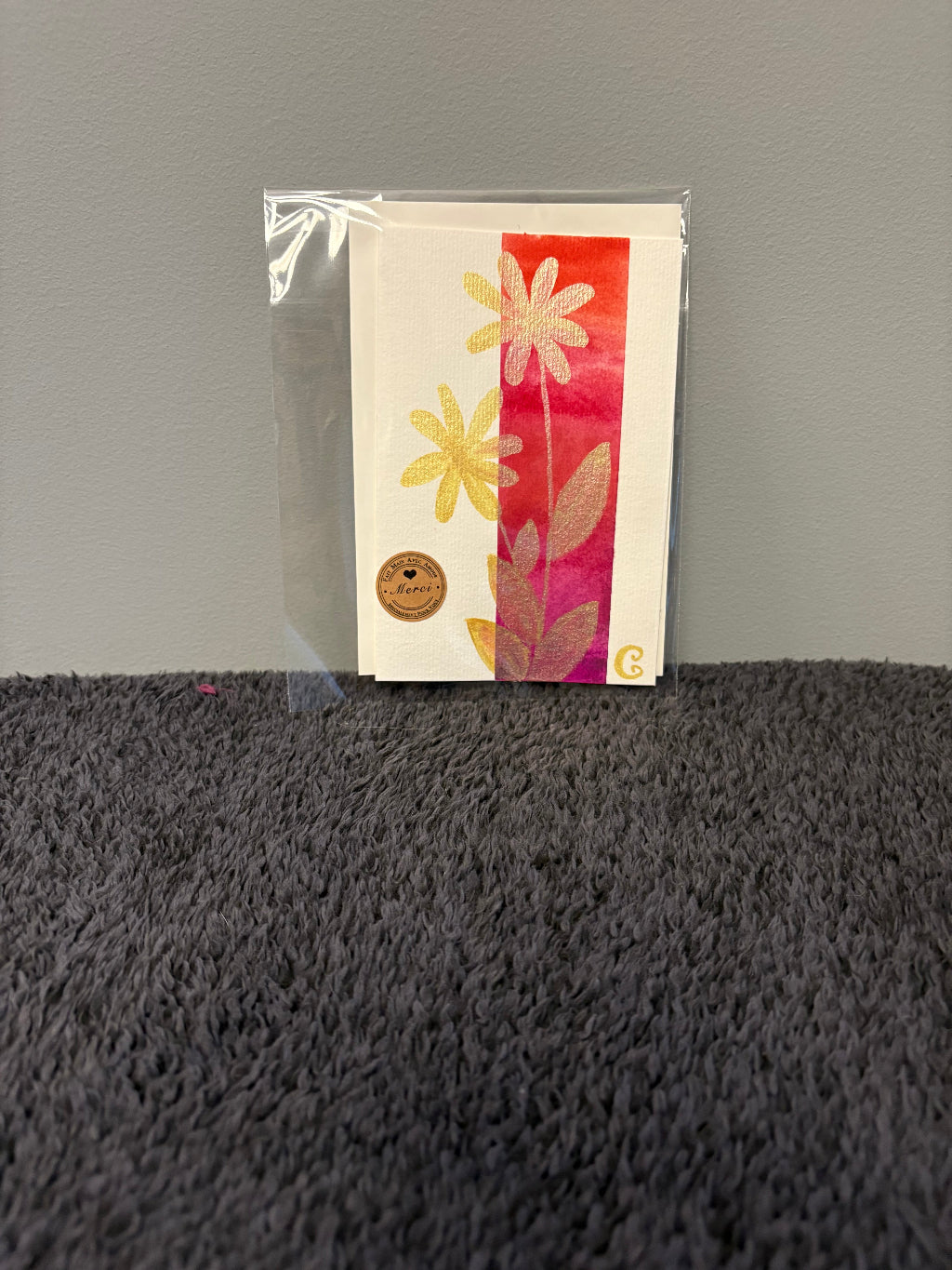 Card with floral design in a clear plastic sleeve 
