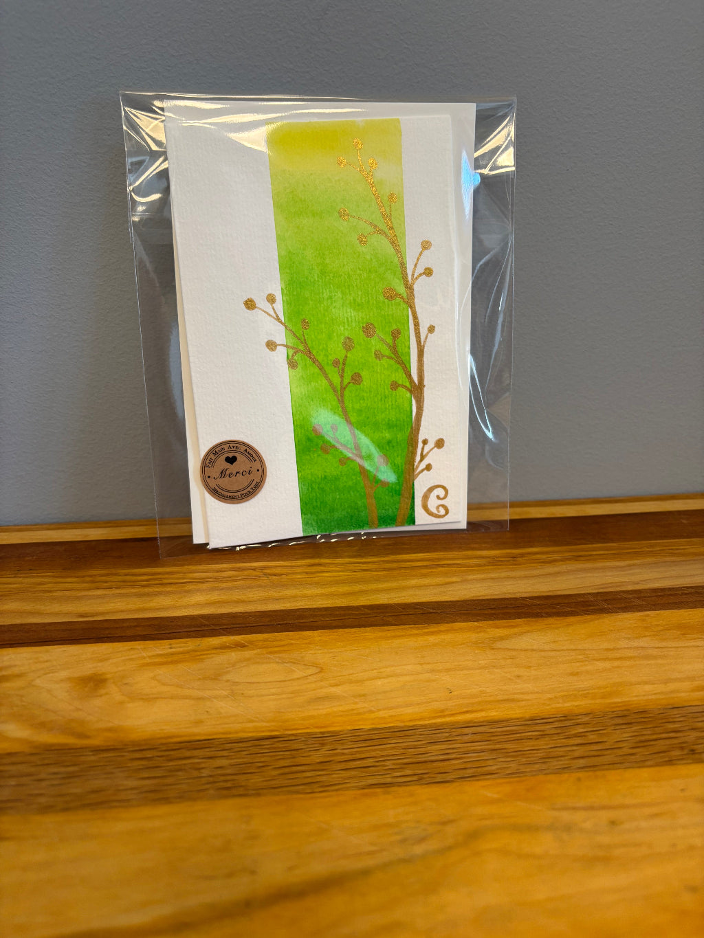 Packaged card with green design on a gray surface