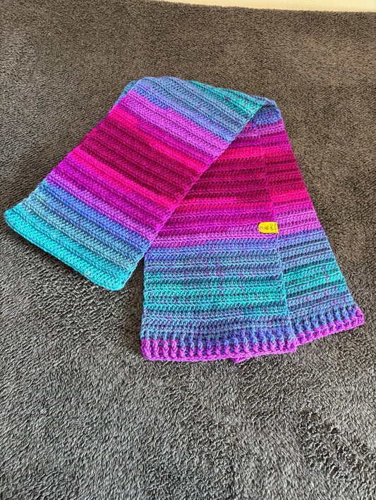 Colorful knitted scarf with a yellow tag on a gray surface