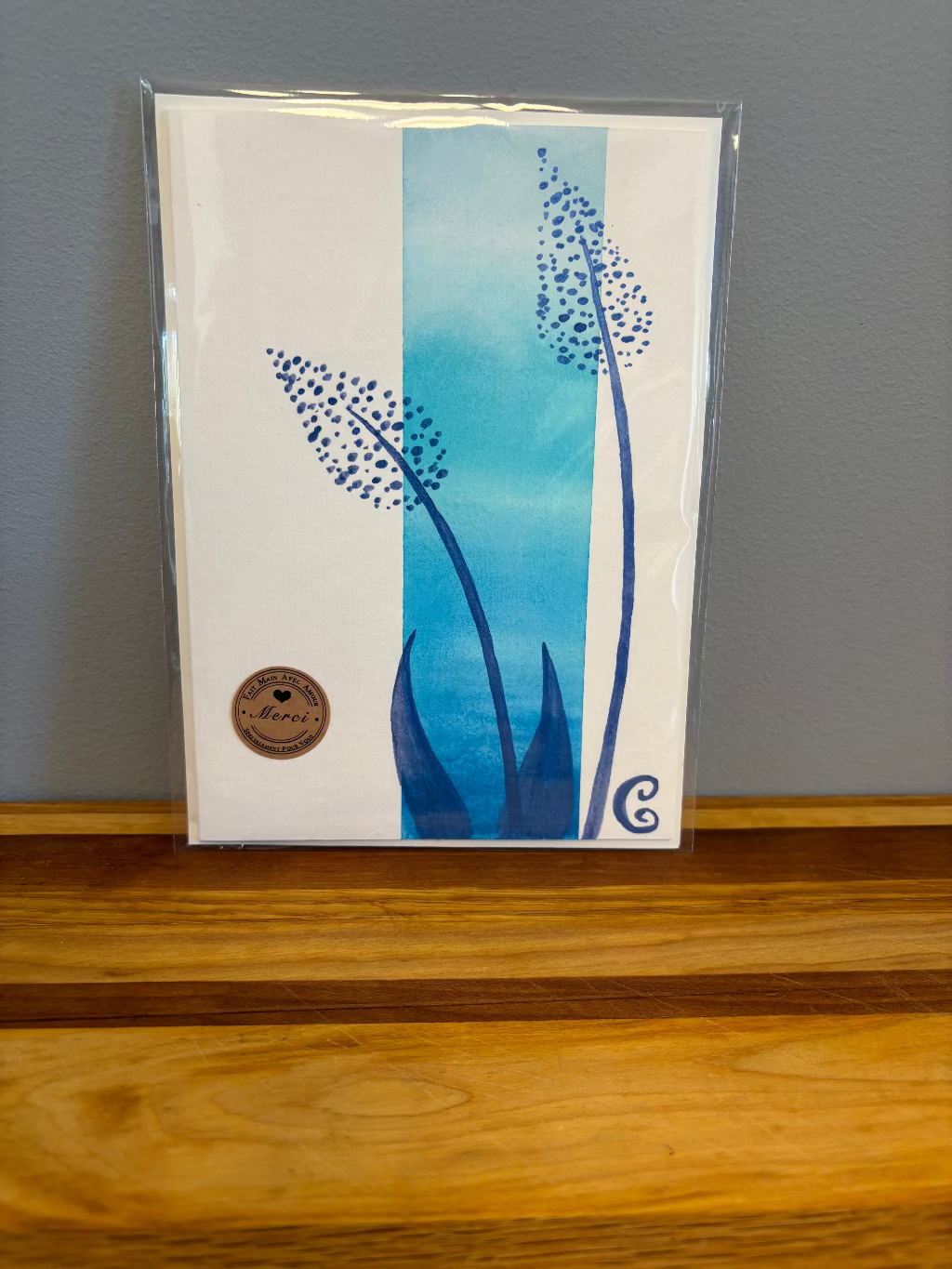 Card with blue floral design on a wooden surface